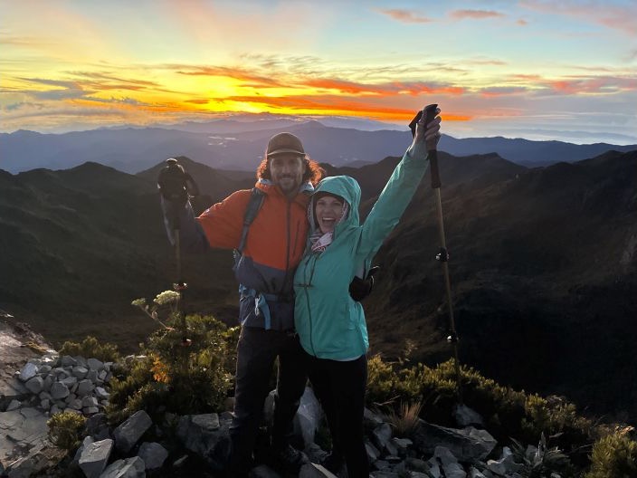 Chasta and Jason hiking together at a mountain summit